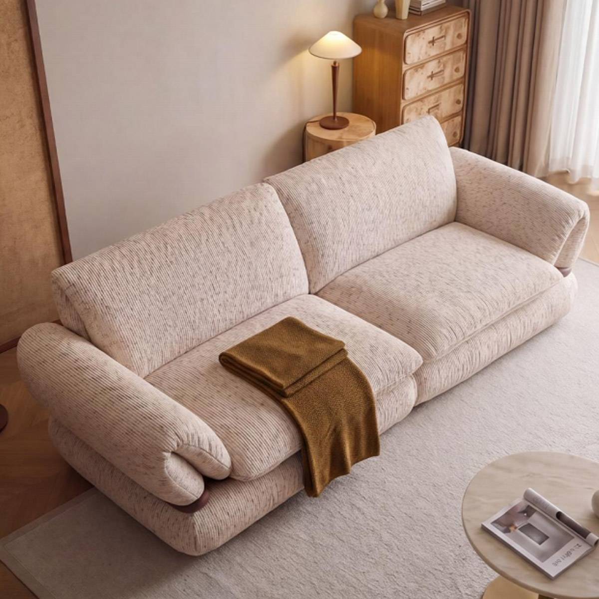 High-angle view of the beige sofa showing the texture of the fabric and the wooden armrests