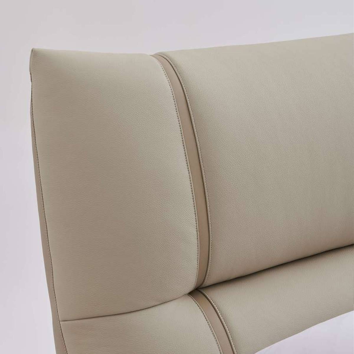 Close-up of beige genuine leather bed headboard showing stitching details