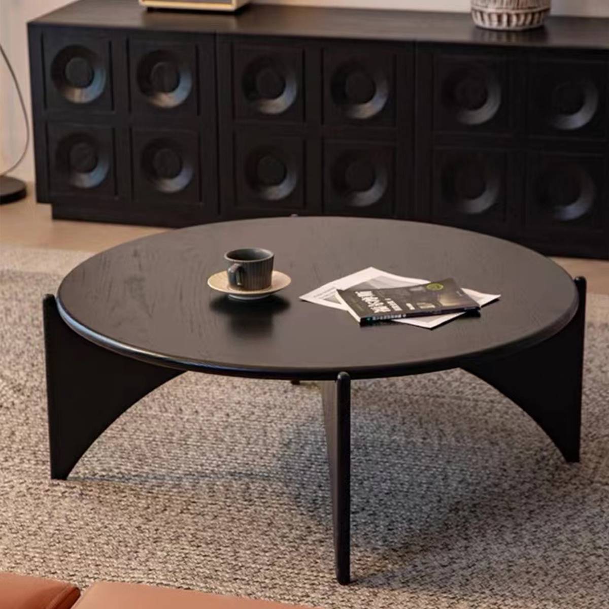 Front view of black coffee table showing curved legs and sideboard background