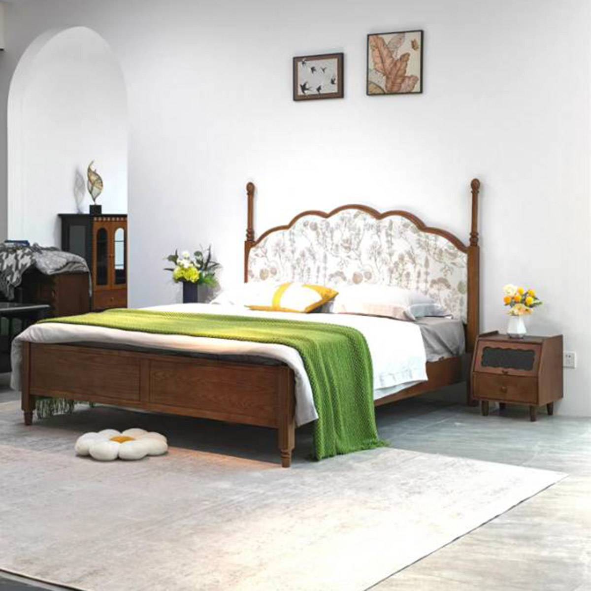 Wide shot of the mid-century upholstered bed in a bedroom setting with a green throw blanket