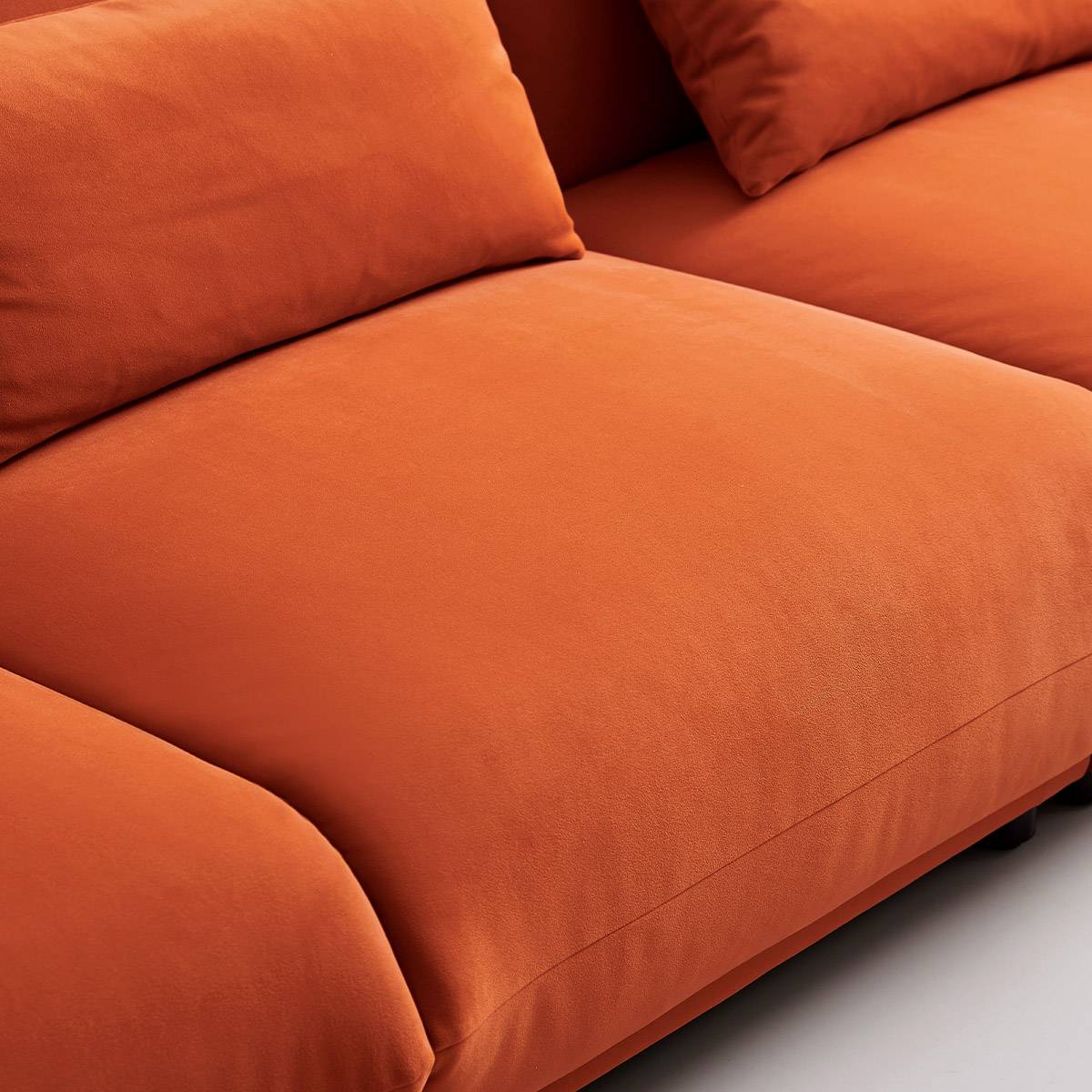 Close-up view of the orange fabric texture on the sofa seat and armrest