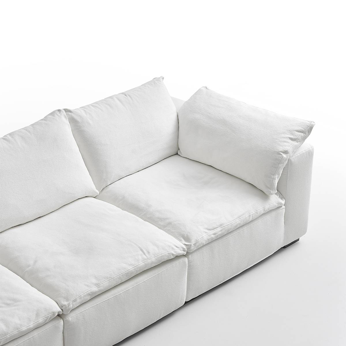 Close-up detail of the sofa seat cushions and back pillows showing fabric texture