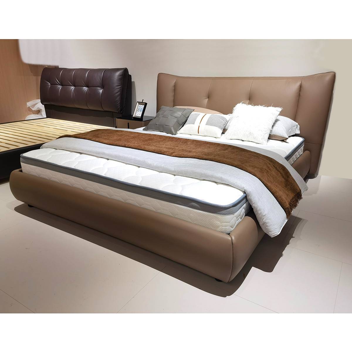 Babylon leather bed in a showroom setting showing the mattress and brown upholstery