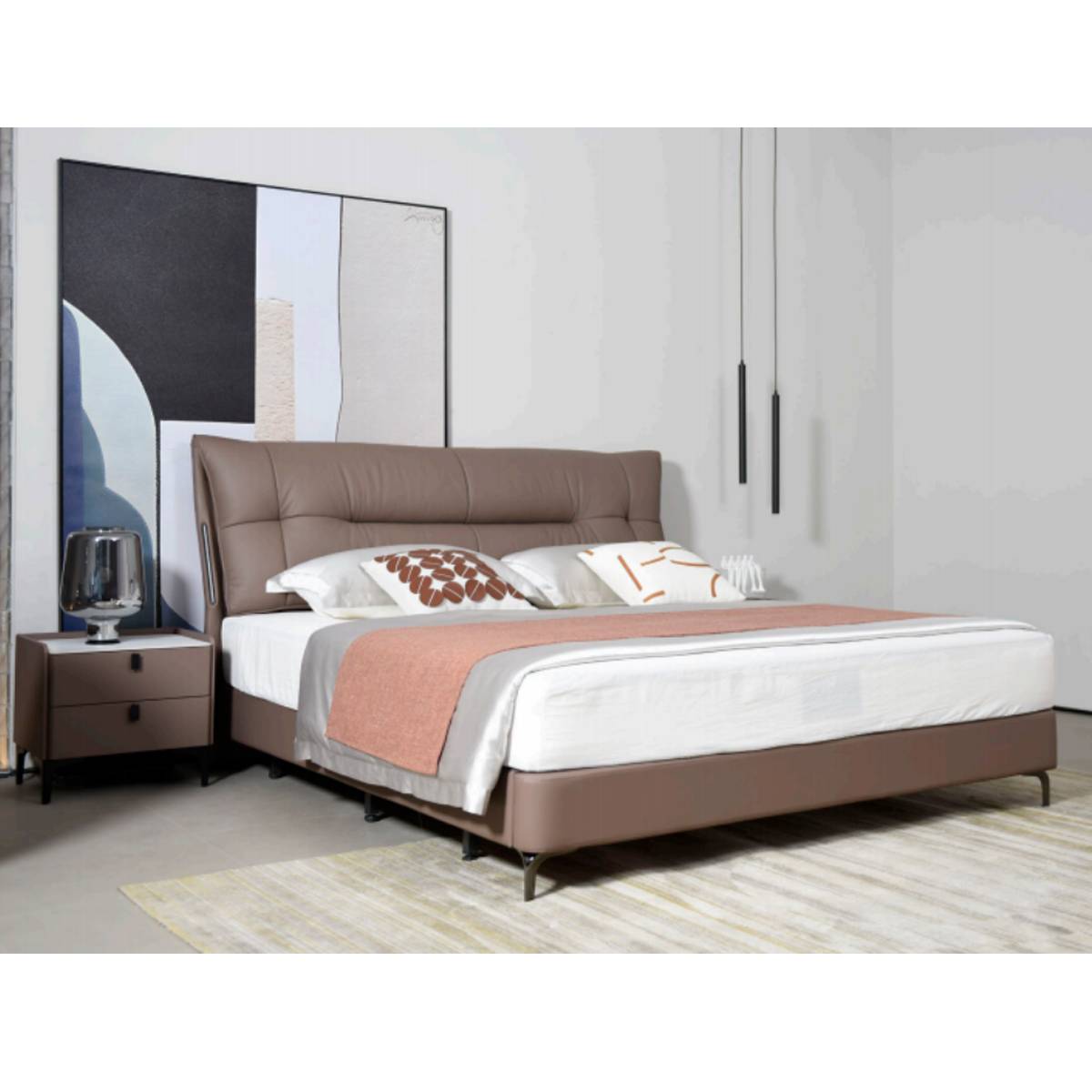 Side view of the bed with a pink throw blanket and decorative pillows