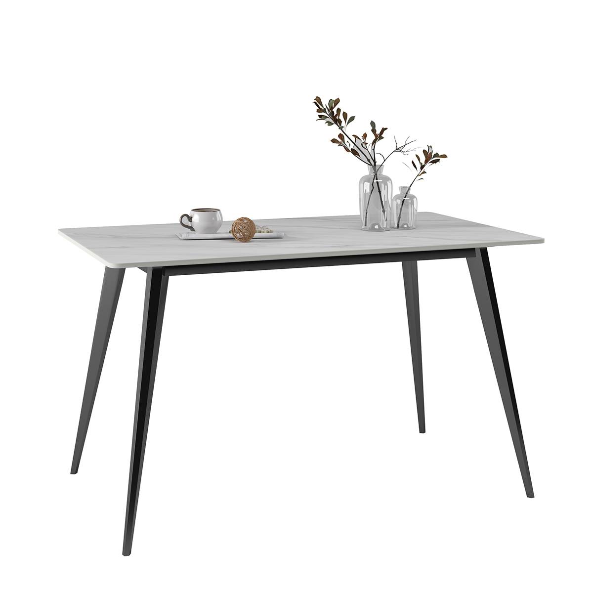White sintered stone dining table with black metal legs and decorative items