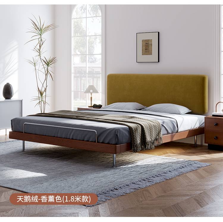 Bed with yellow velvet headboard and wooden frame
