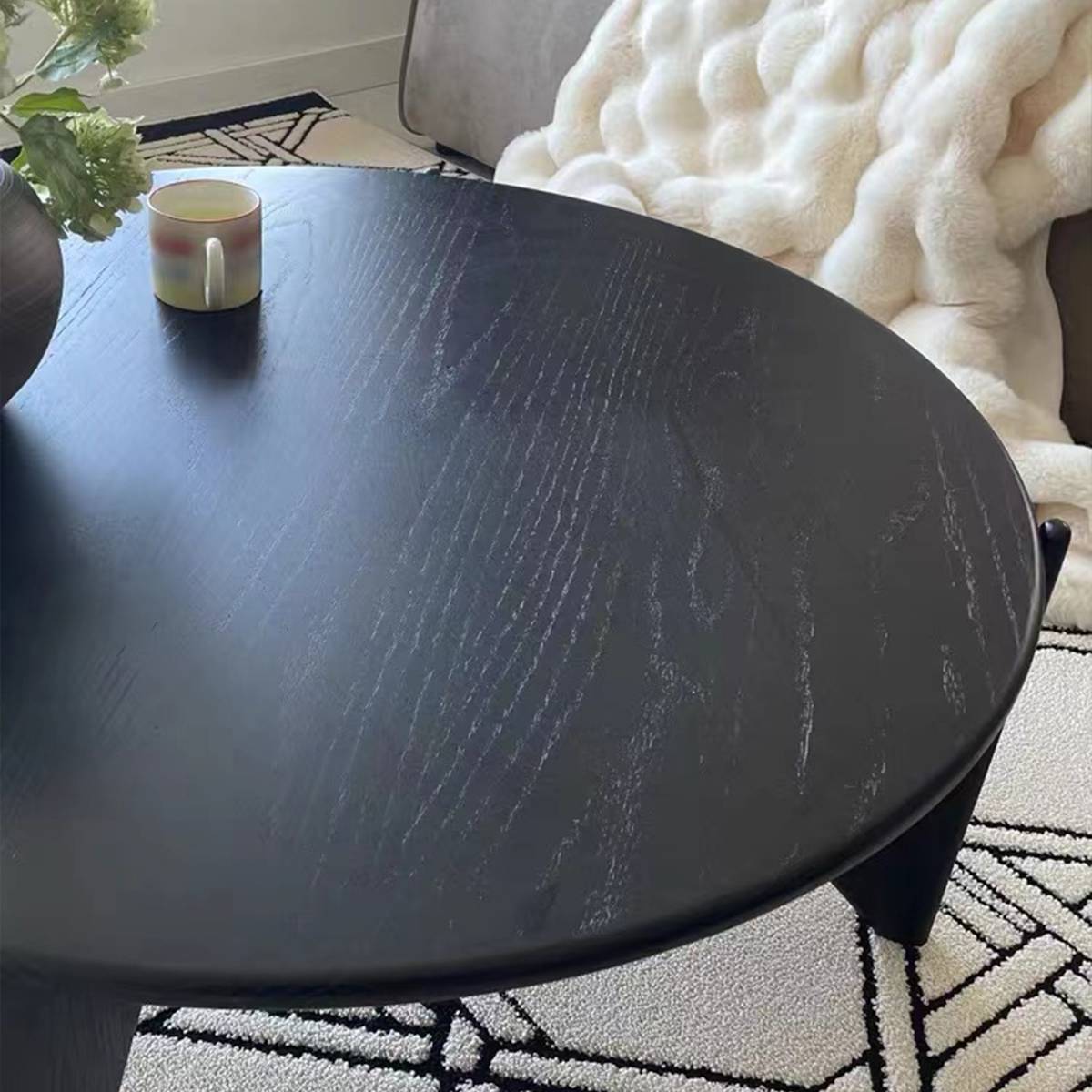 Close up of black coffee table surface showing wood grain texture