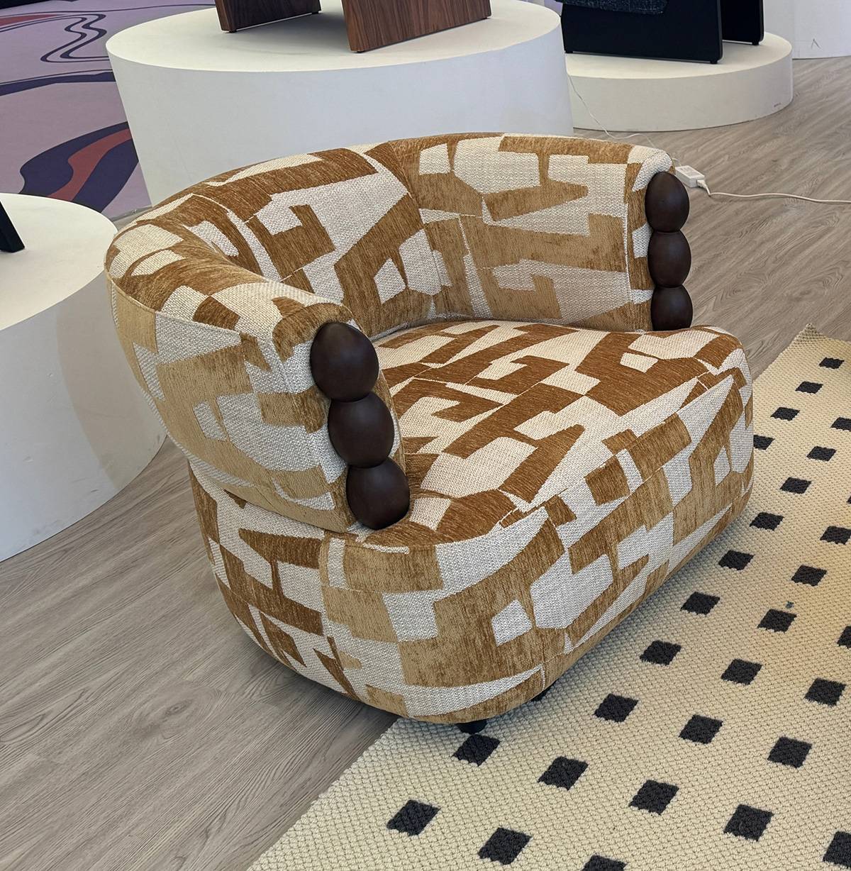 Close-up of the brown and beige geometric patterned lounge chair with wooden bead armrests