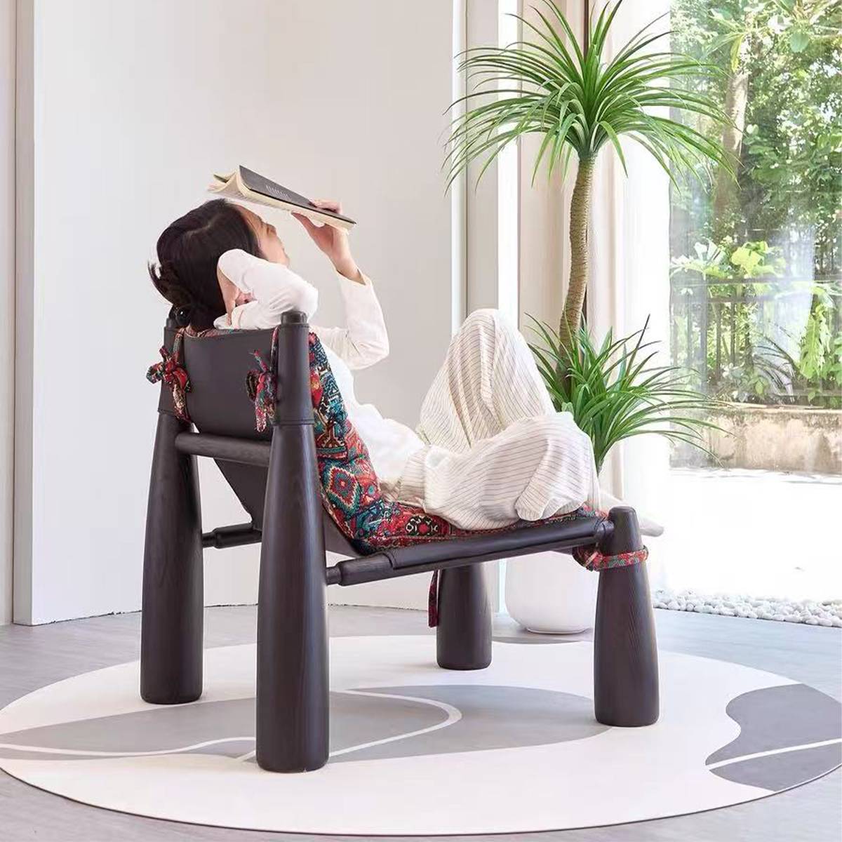 Person relaxing on the lounge chair reading a book