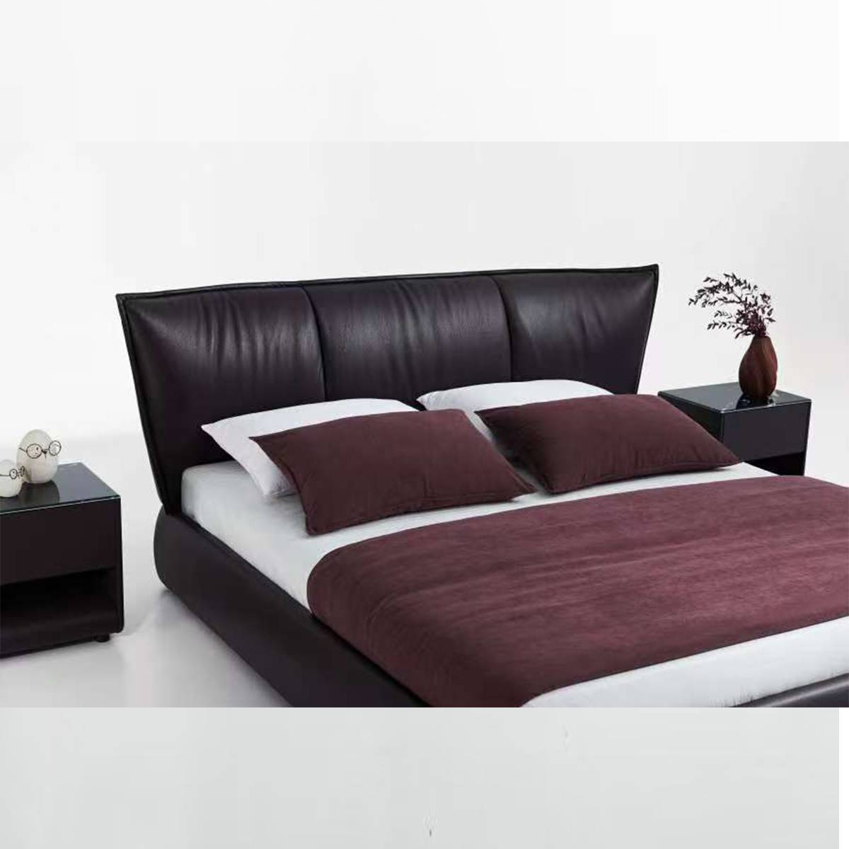 Full view of the dark red leather soft bed with white bedding and side tables
