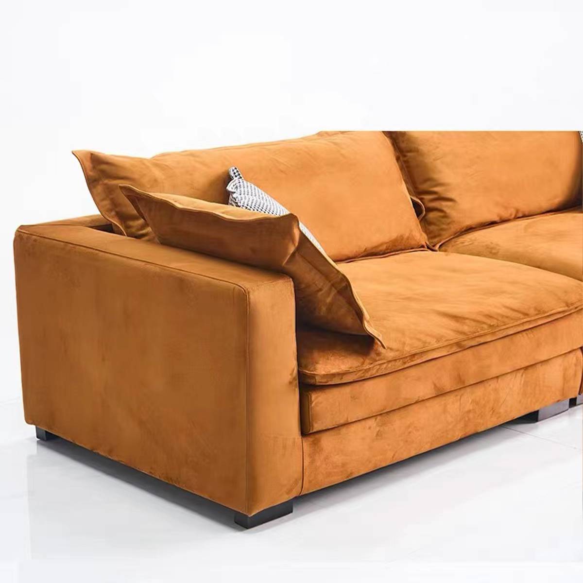 Close-up side view of orange fabric sofa showing cushion texture