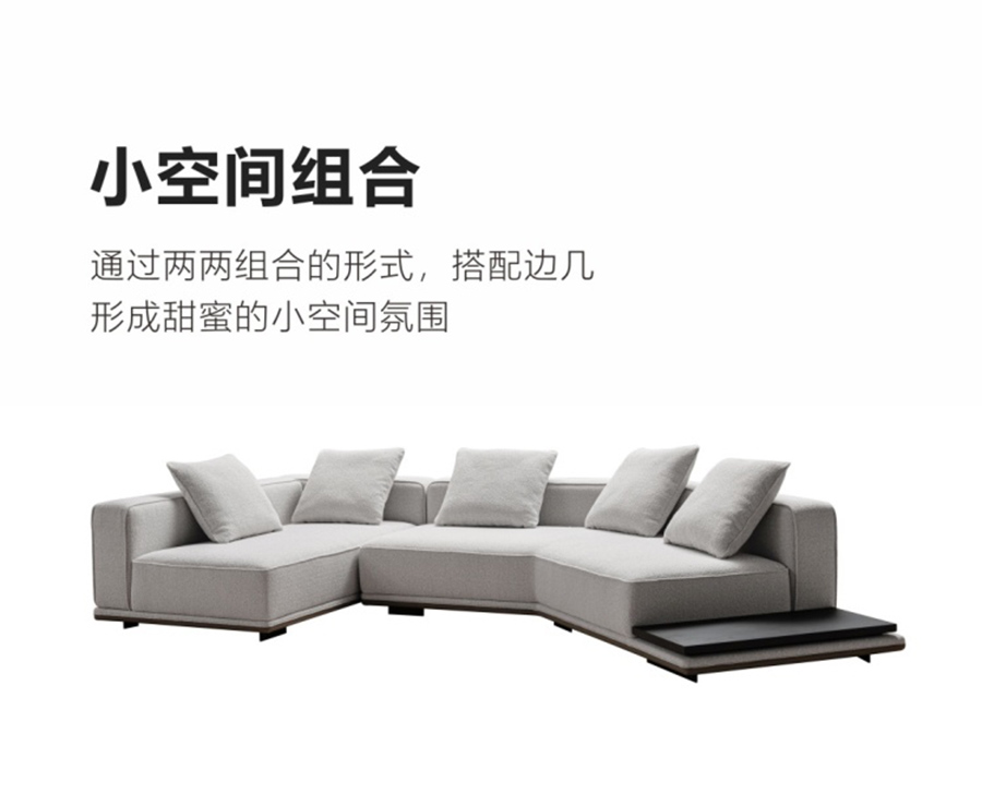 High-angle studio shot of a light grey modular sectional sofa with an attached side table and round coffee table.