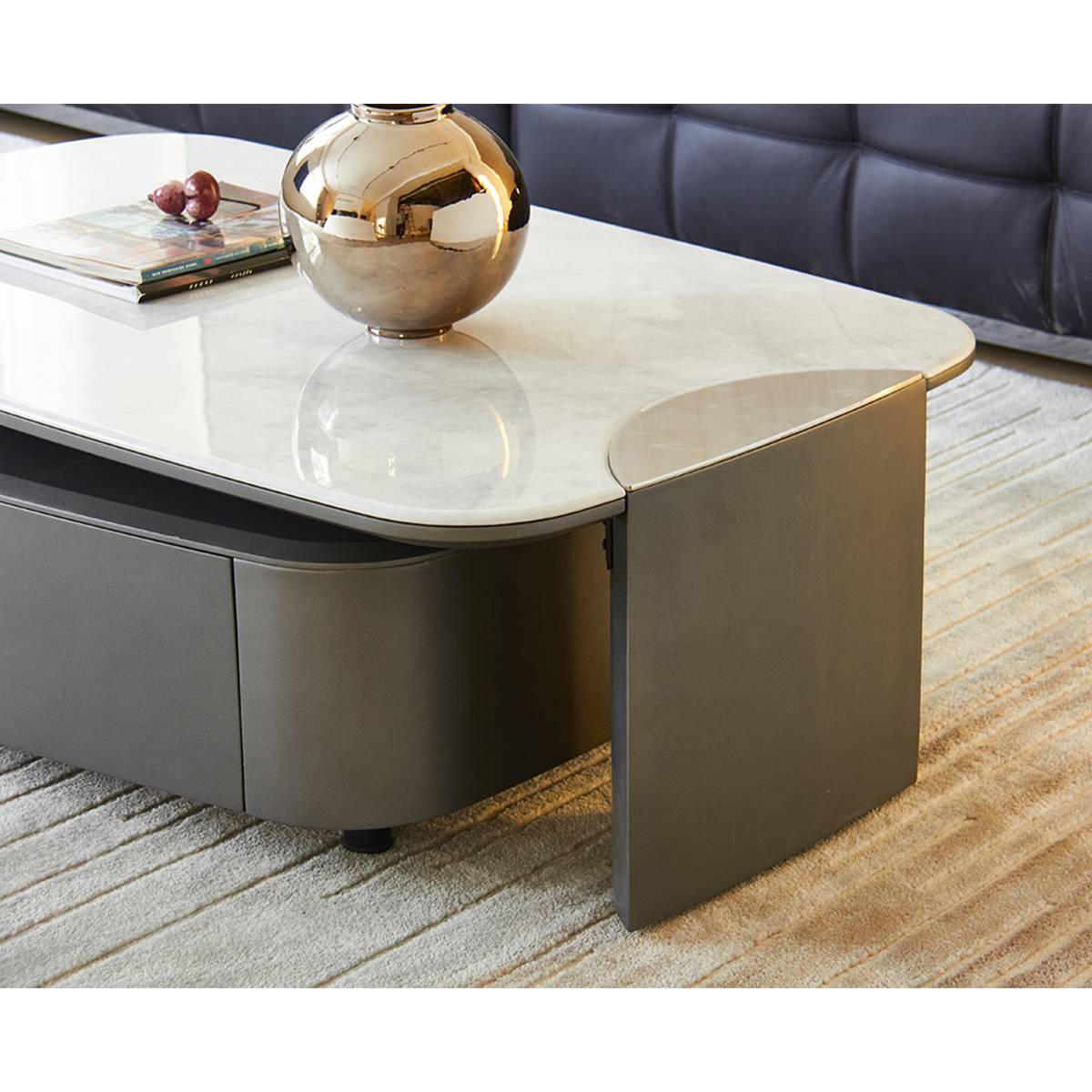 Close-up of the coffee table corner showing the stainless steel leg and stone top edge.