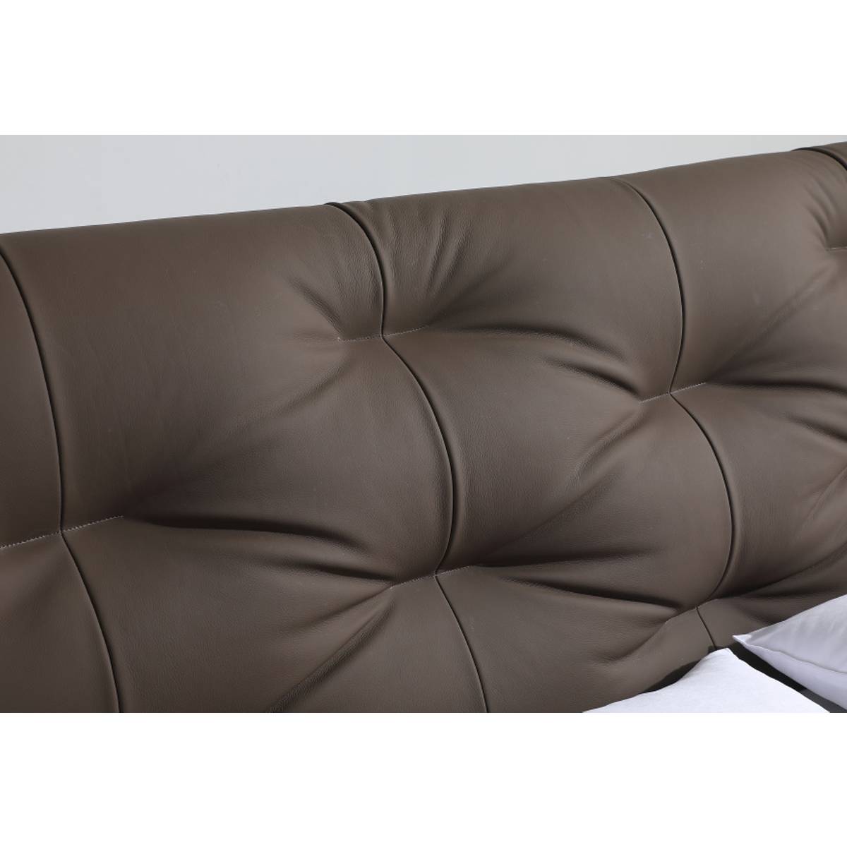 Close-up of brown tufted leather headboard