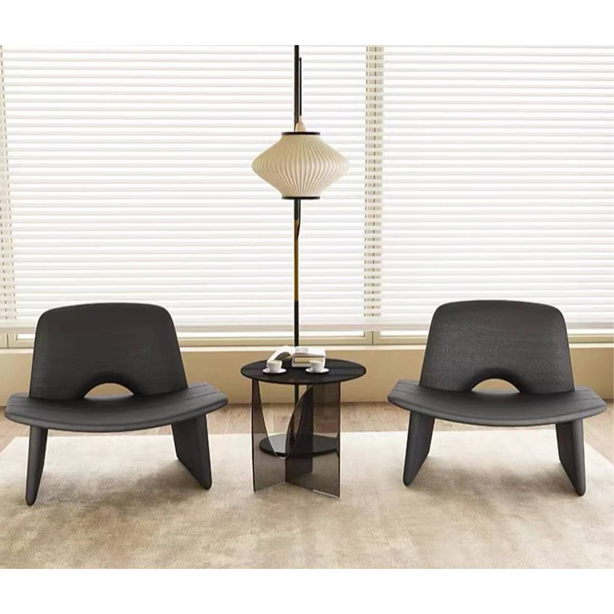 Two black lounge chairs placed in a living room setting with artwork