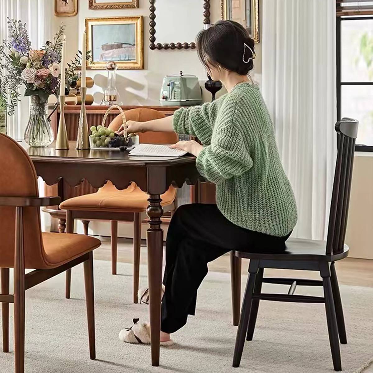 Side view of a woman sitting at a mid-century dining table with a scalloped apron