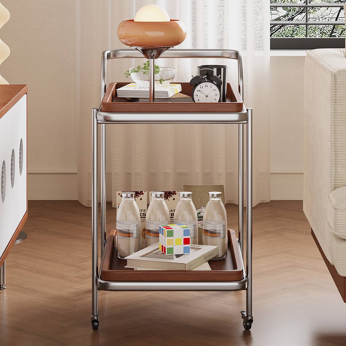 Front view of the stainless steel and wood mobile side table with items on shelves