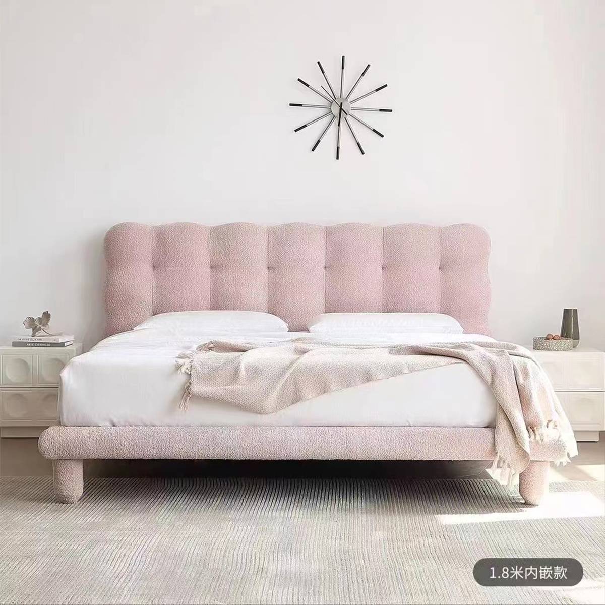 Front view of pink lambswool bed with starburst clock on wall
