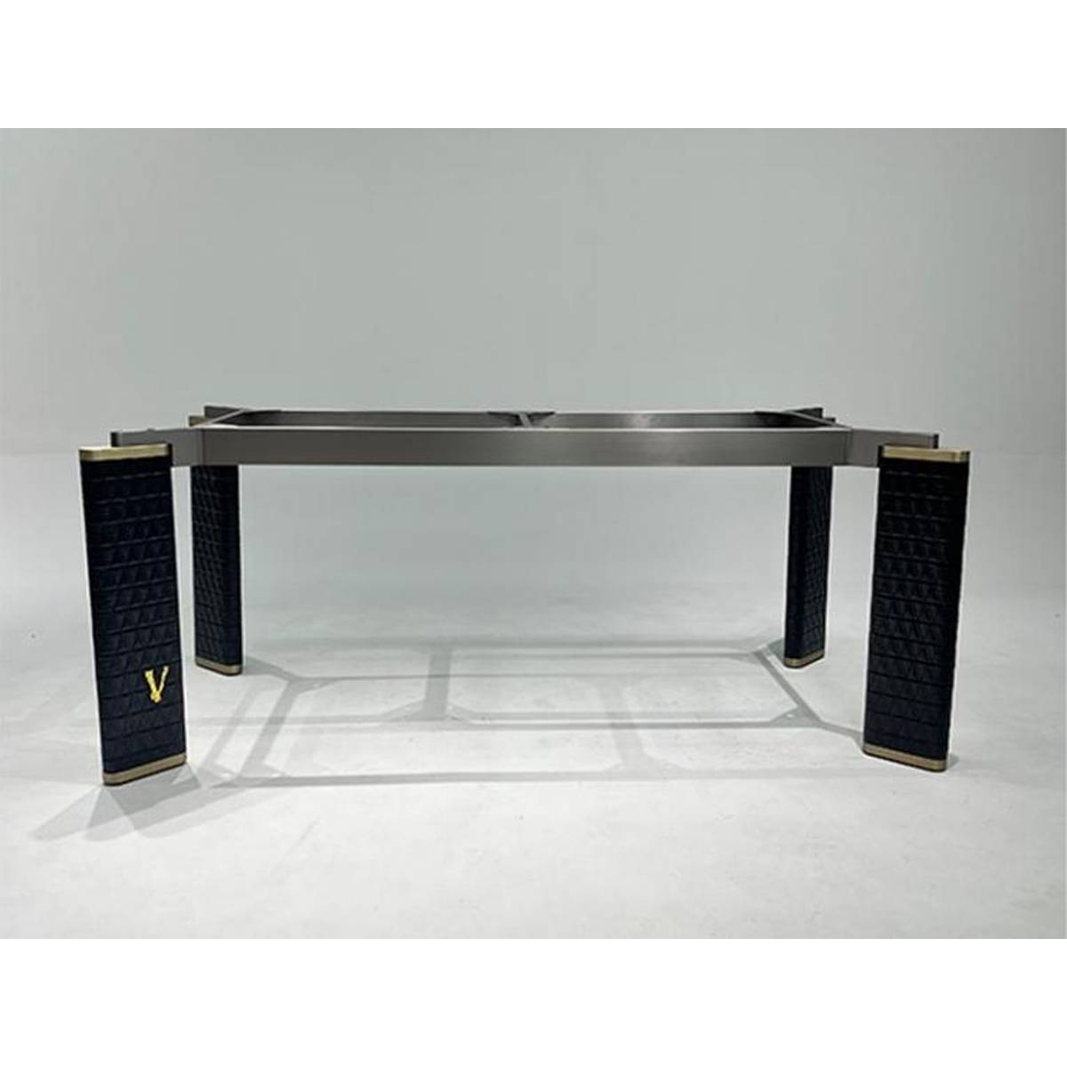 Underside view of the dining table showing the stainless steel frame and leather legs