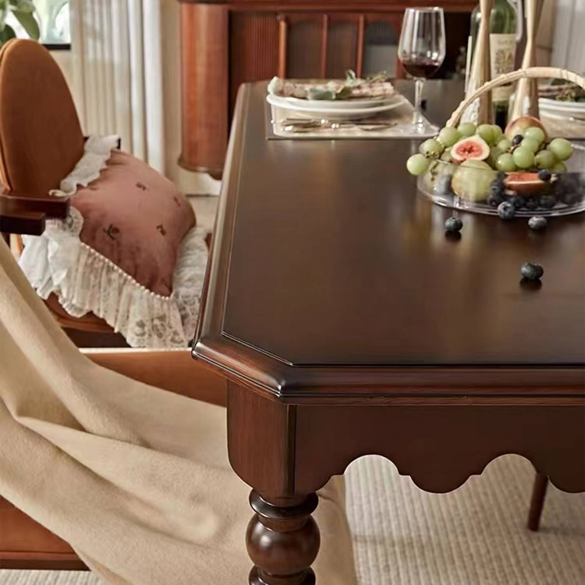 Close-up detail of the dining table corner showing the scalloped apron and turned leg