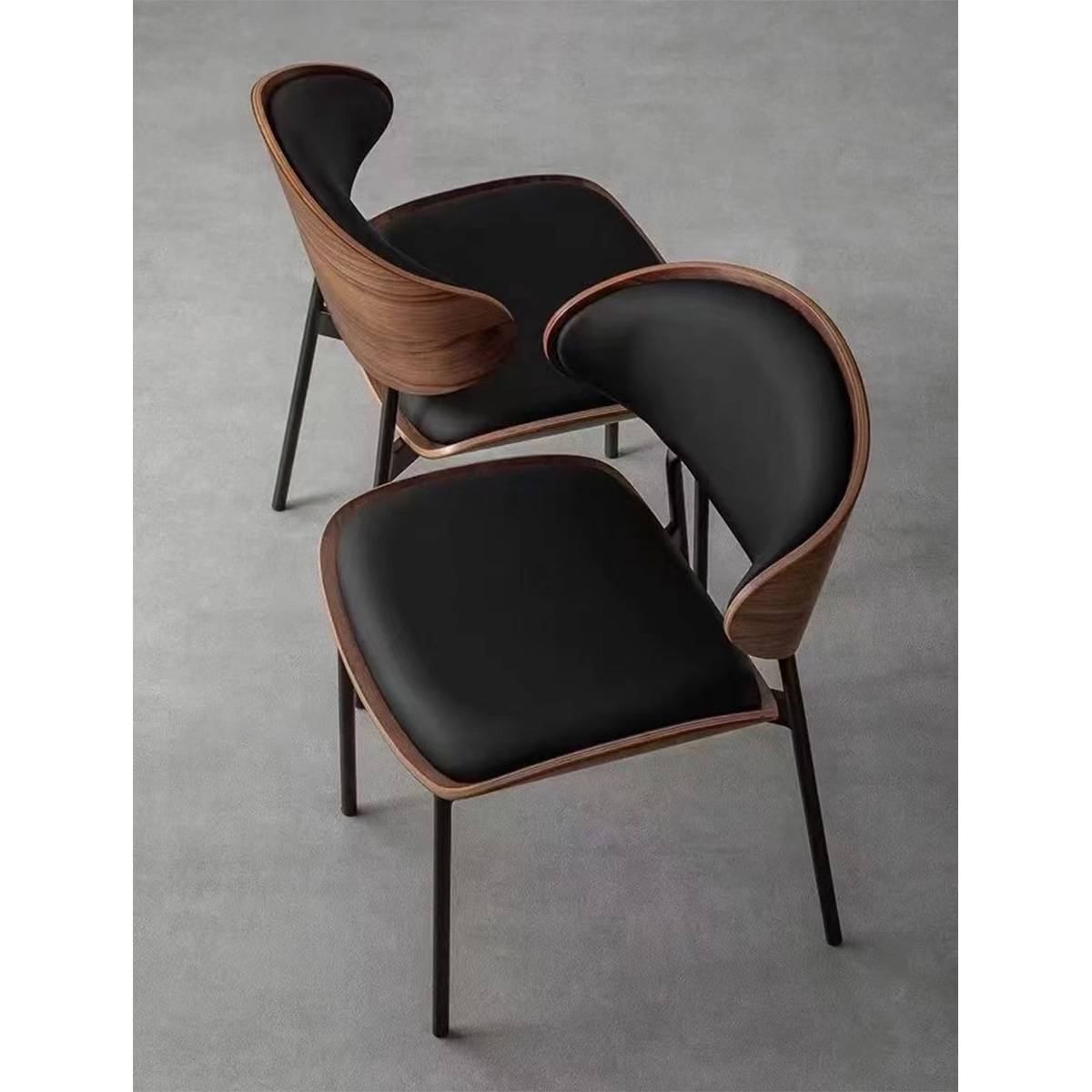 High angle view of two mid-century dining chairs showing the wood grain and metal legs