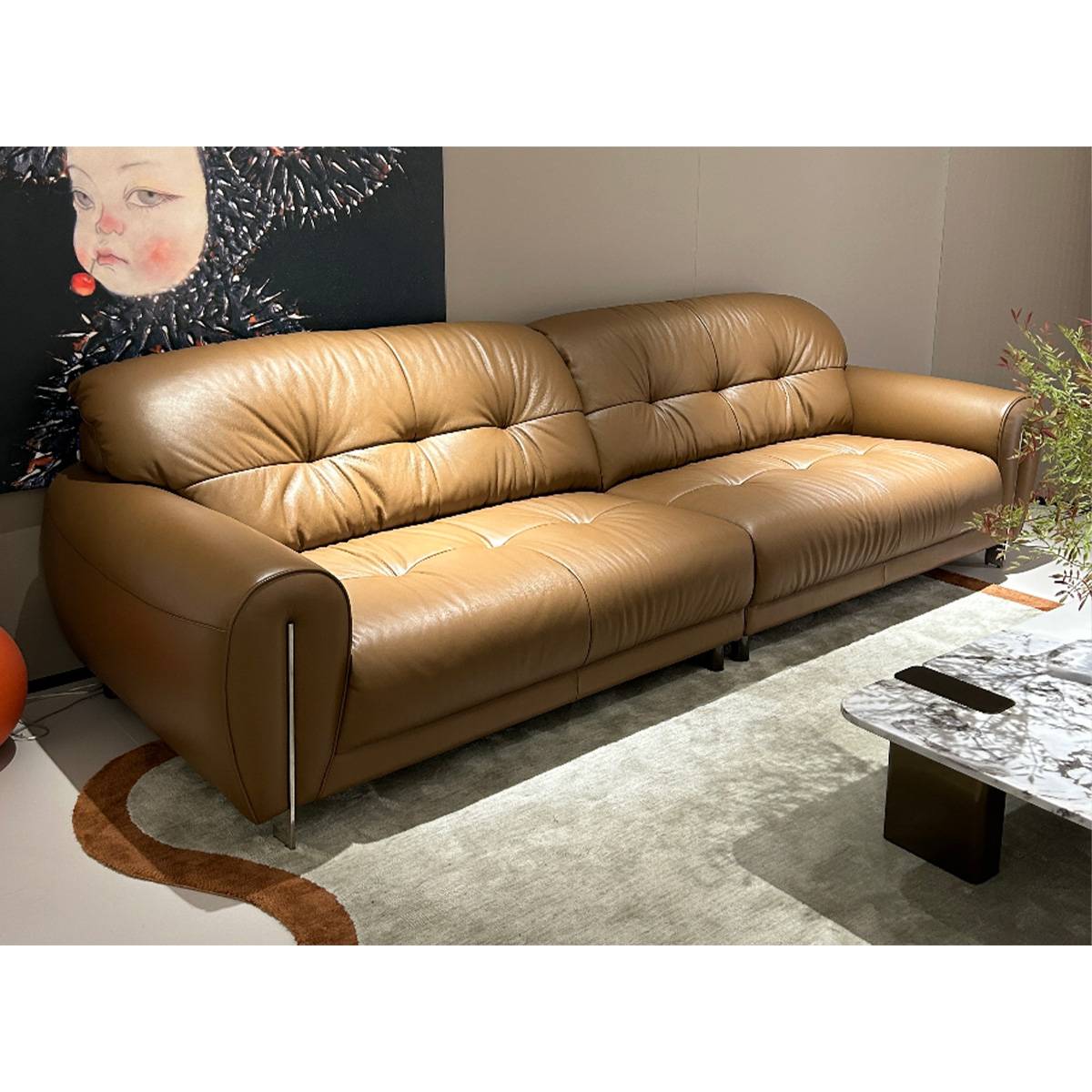 Close-up angle of the brown leather sofa showing the texture and armrest details