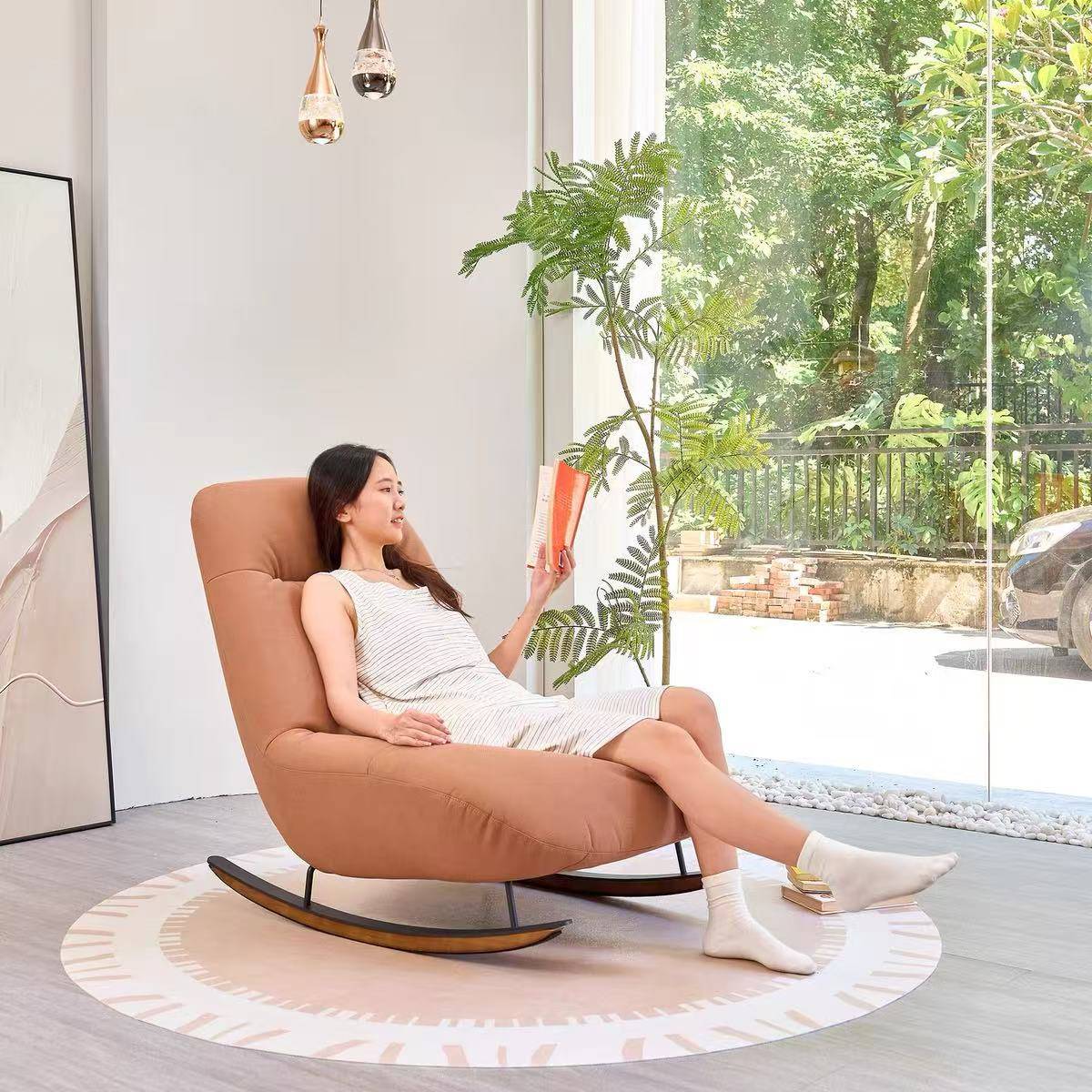 Side view of the rocking lounge chair with a woman reading a book