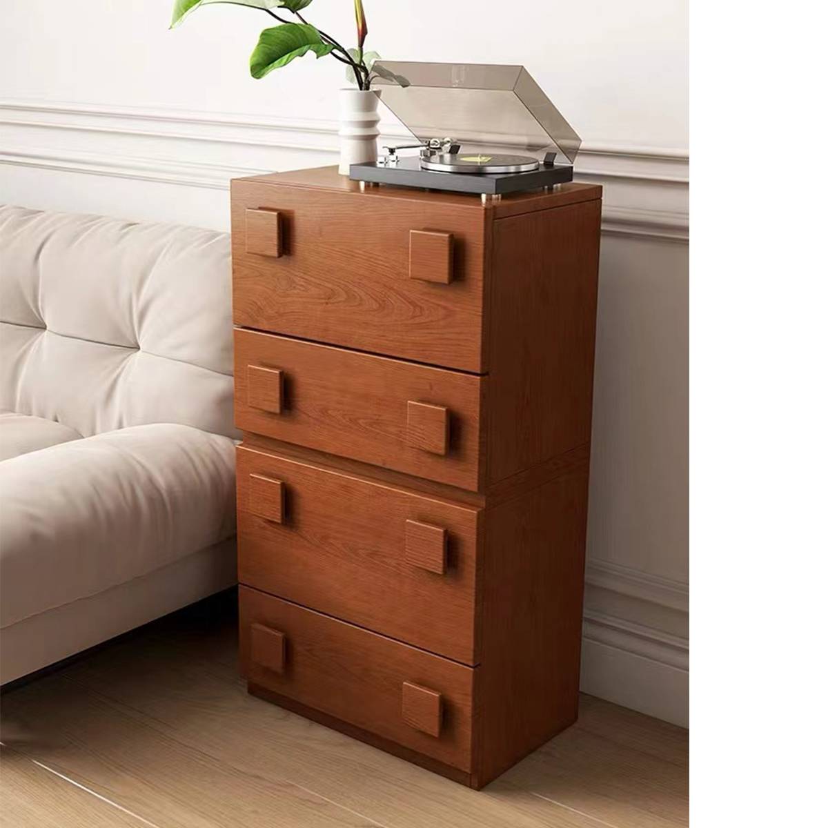 Wooden storage cabinet used as a bedside table with a record player on top