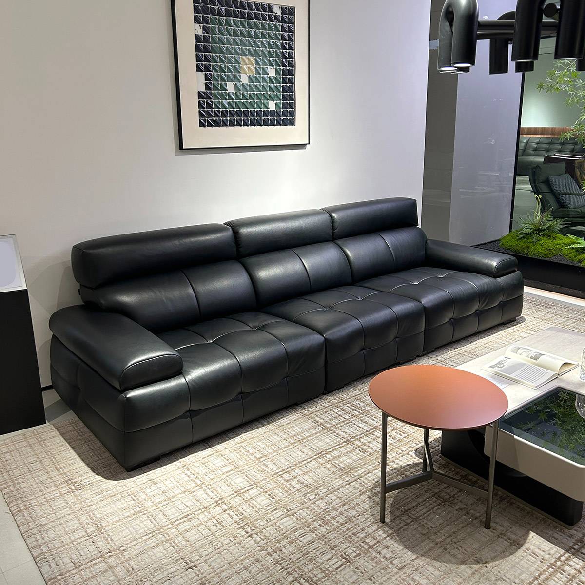 Full view of black leather sofa in a modern living room setting