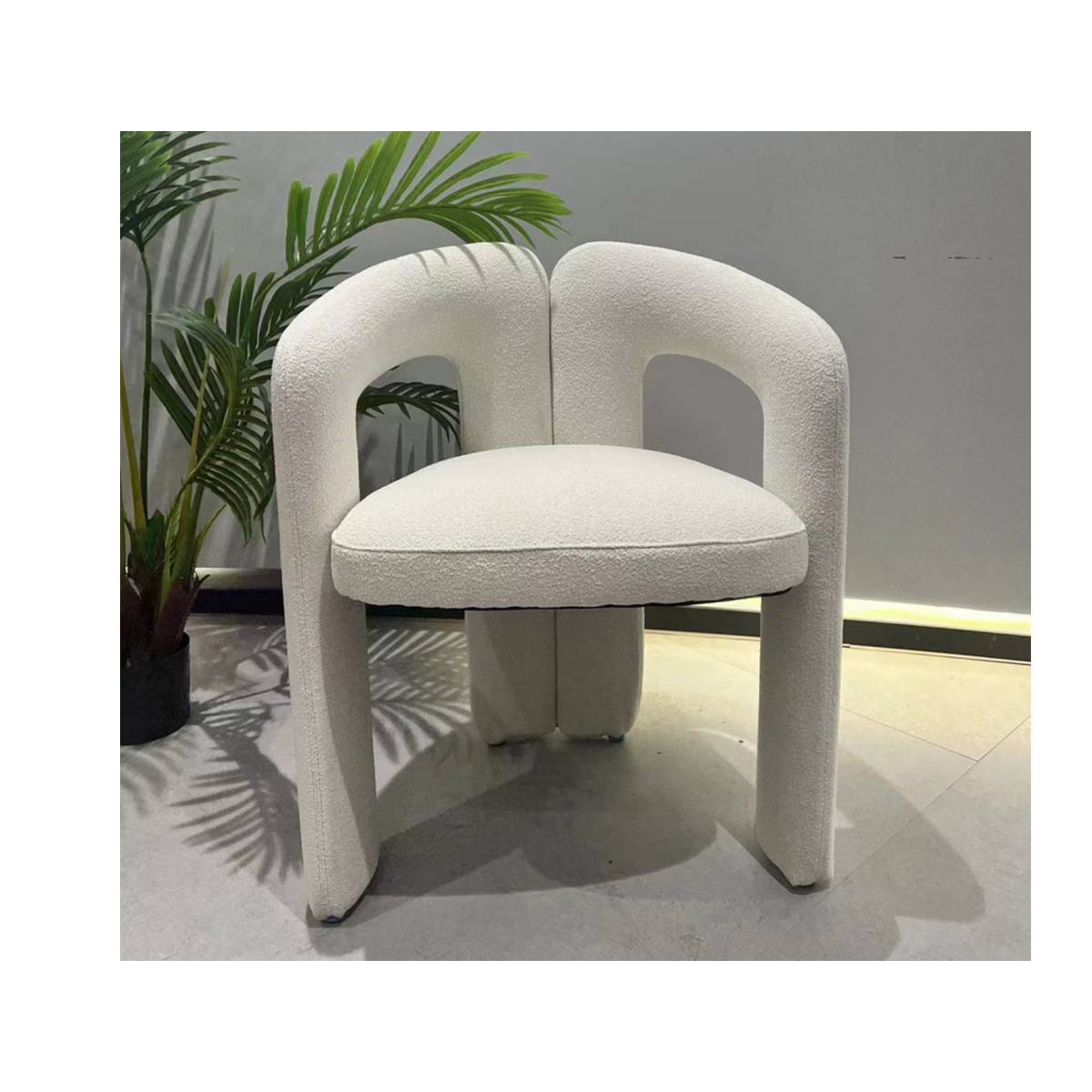 White modern lounge chair with curved backrest and fabric upholstery