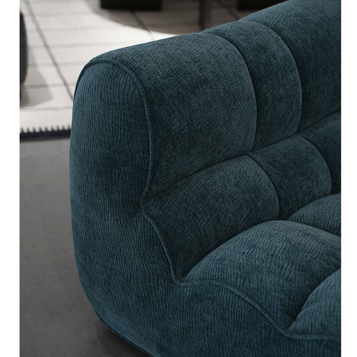 Side view of the teal lounge chair showing the segmented backrest and armrest design