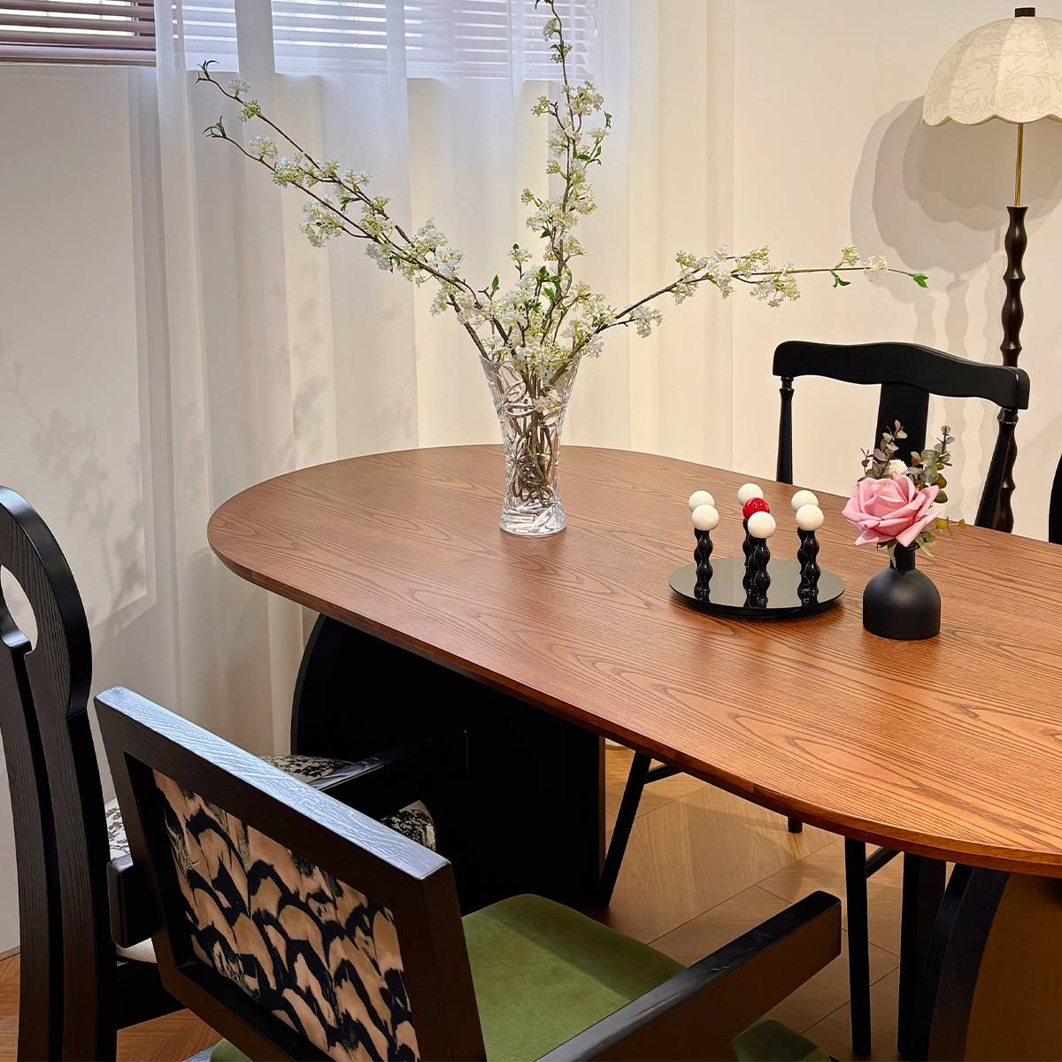 Close-up of the walnut dining table surface with vase and candle holders