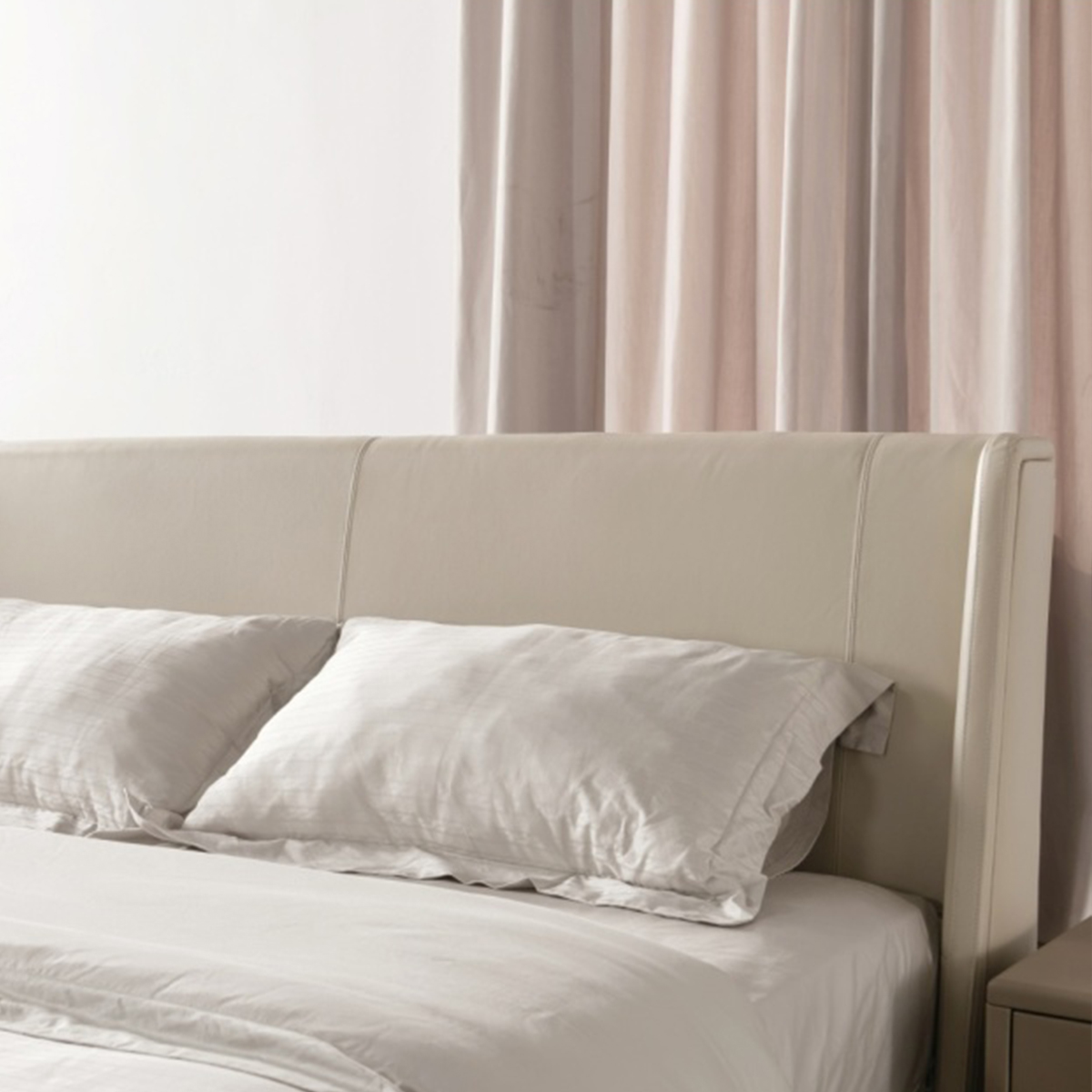 Close-up of the beige leather headboard showing stitching details