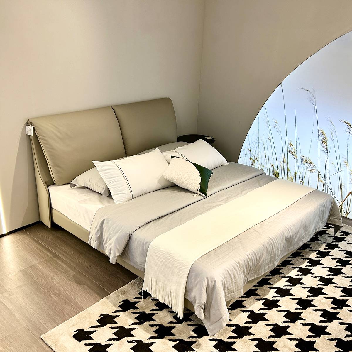 Angled view of the bed in a modern bedroom setting with an arched window