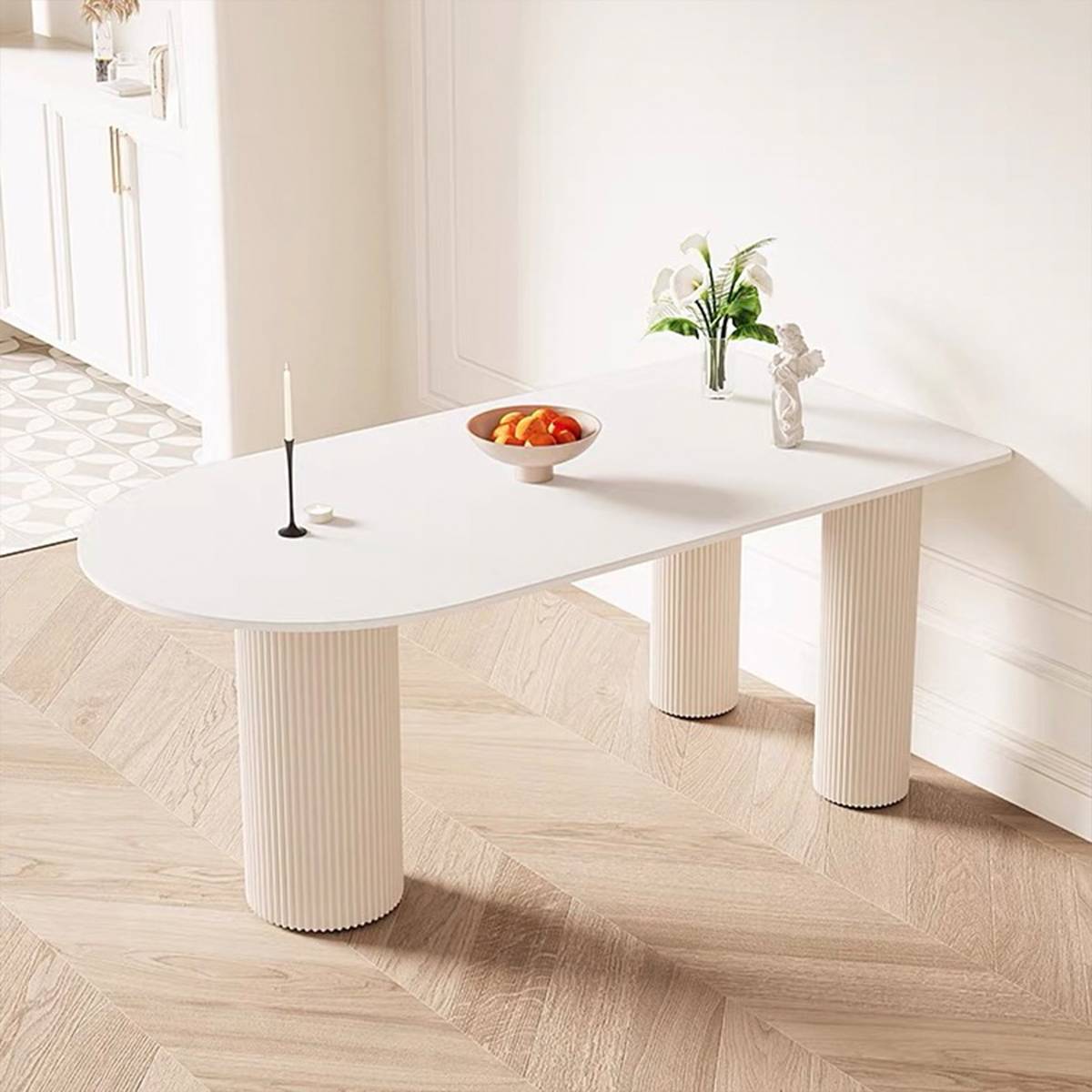 Close-up of the white dining table showing the fluted leg design and sintered stone surface