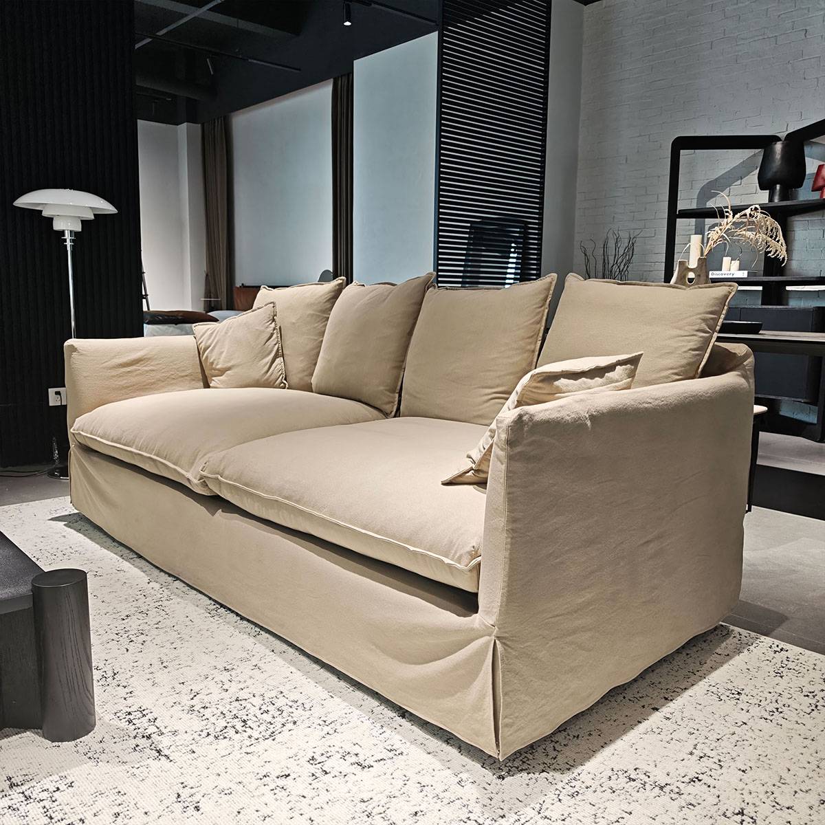 Side angle view of the Selu fabric sofa showing the skirted base