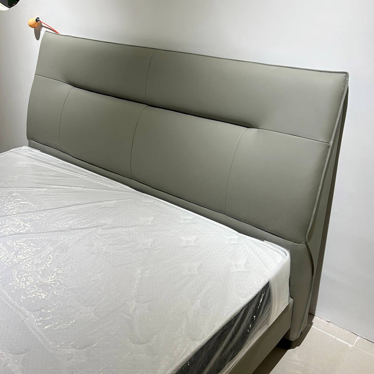 Side view of the grey leather bed frame with mattress