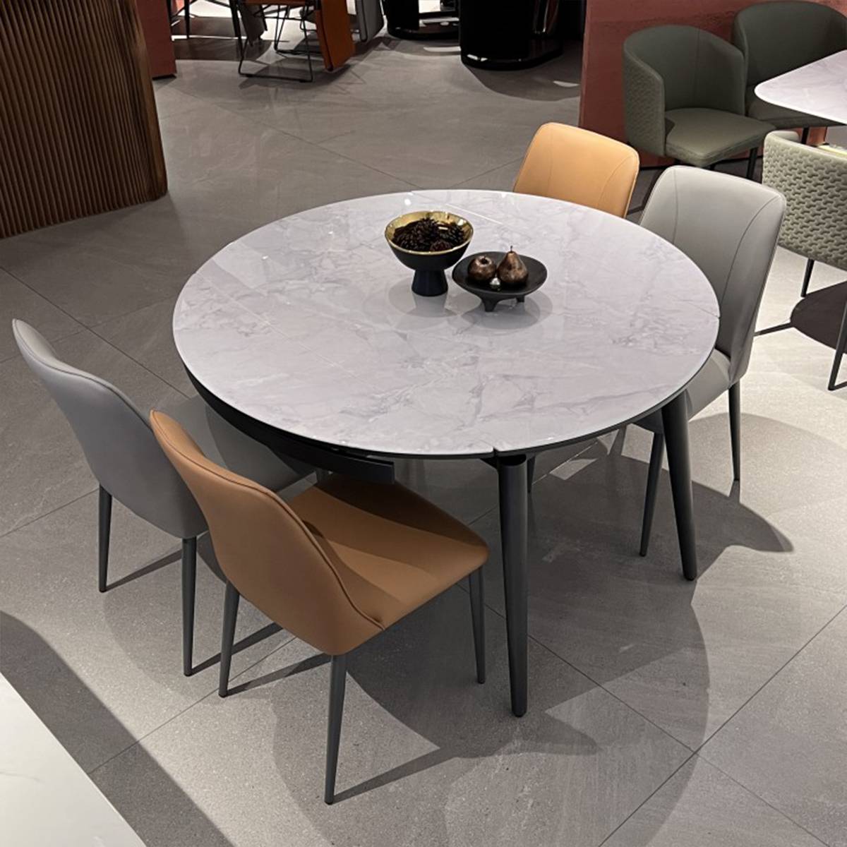 Dining table in round mode with mixed grey and tan chairs