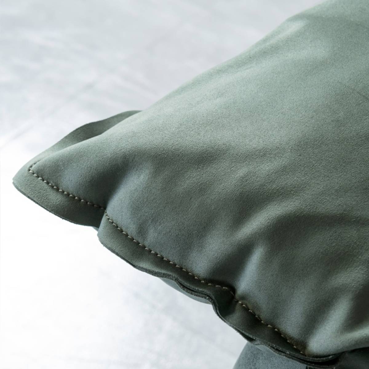 Side angle view of the green sofa showing the back cushions and armrests