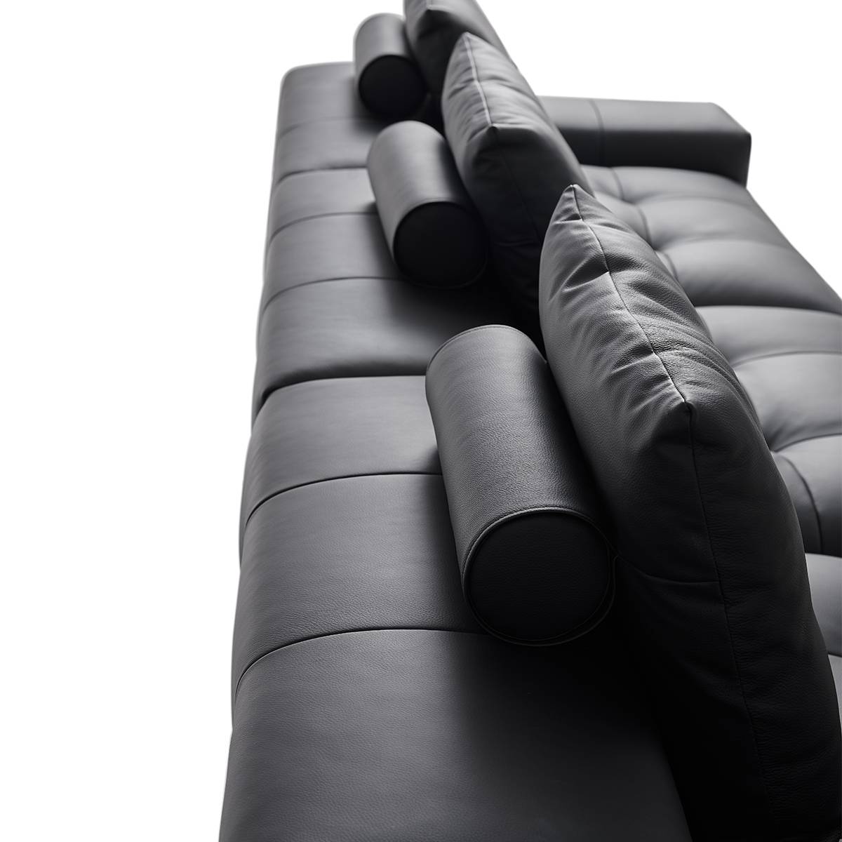 Side profile view of the sofa showing the cylindrical bolster pillows and back cushions