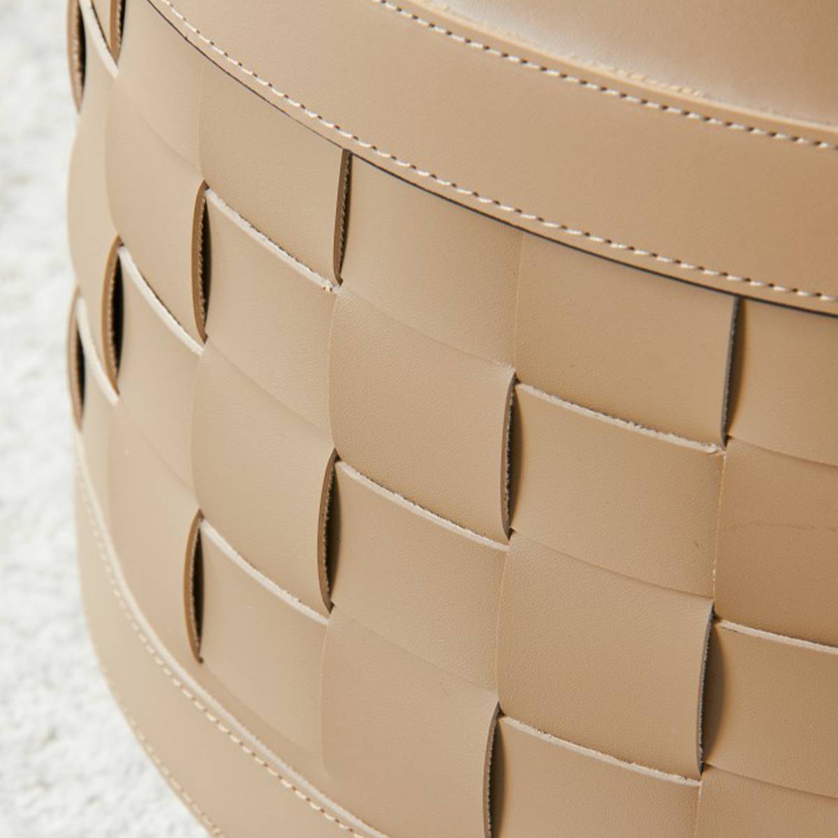 Detail shot of the woven saddle leather texture on the lower storage basket