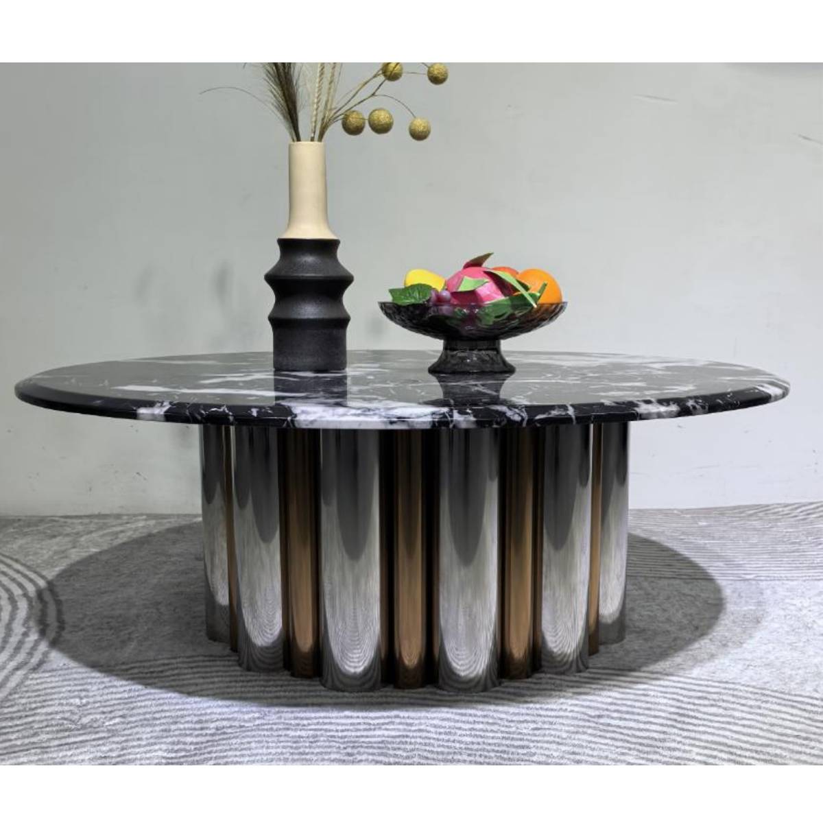 Close-up view of the fluted stainless steel base and marble top of the coffee table