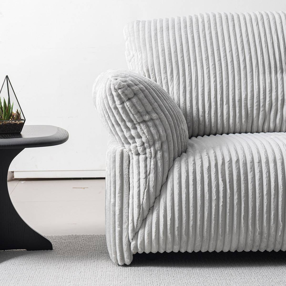 Close-up of the sofa armrest showing the corduroy fabric texture