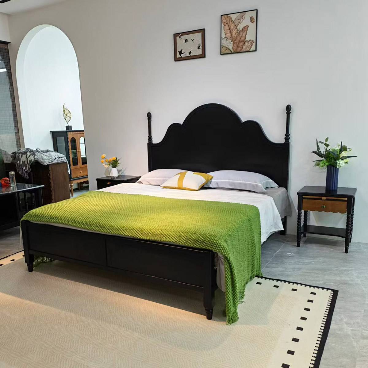 Wide angle view of black finish bed in a room with arched doorway