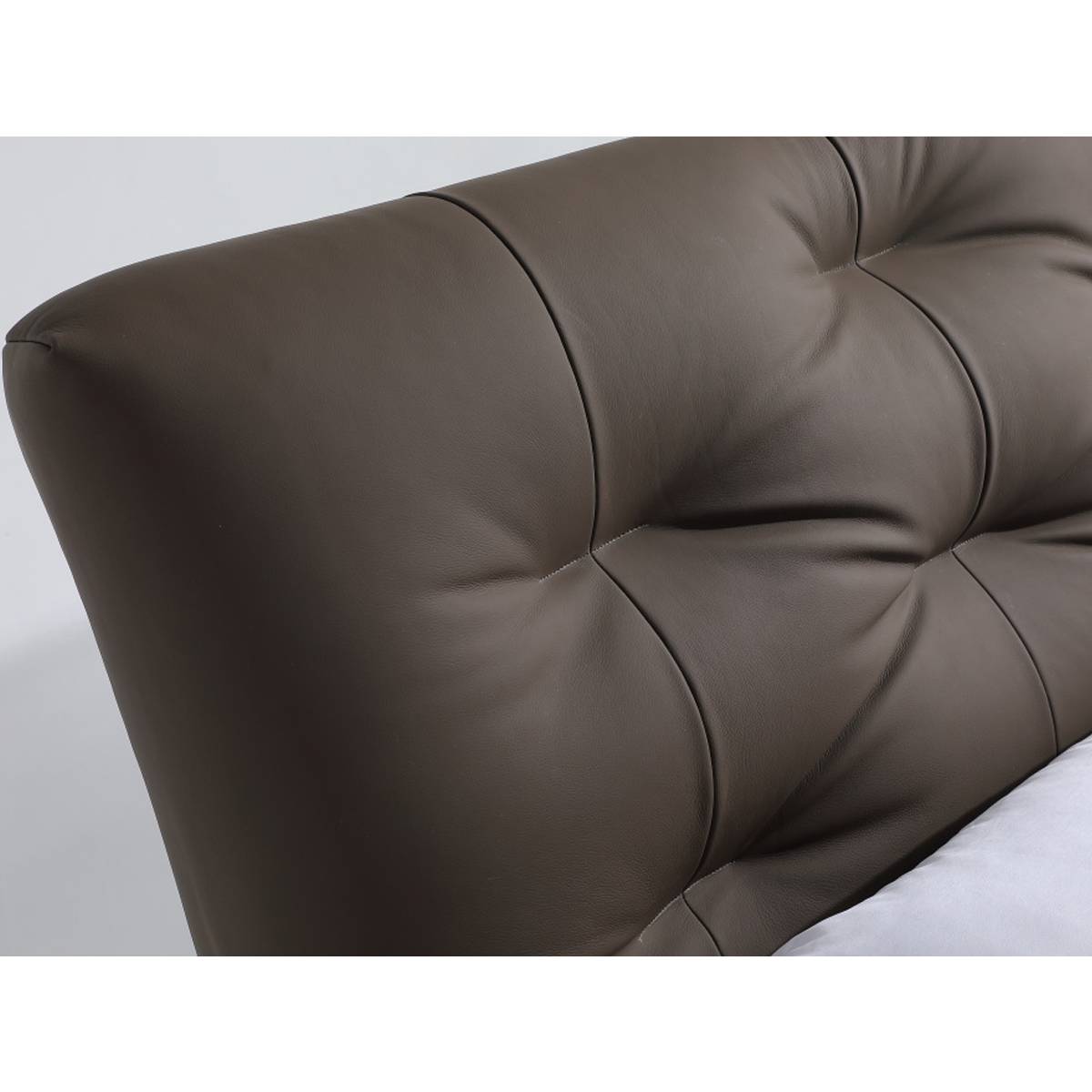 Close-up detail of the tufted leather headboard showing texture and stitching