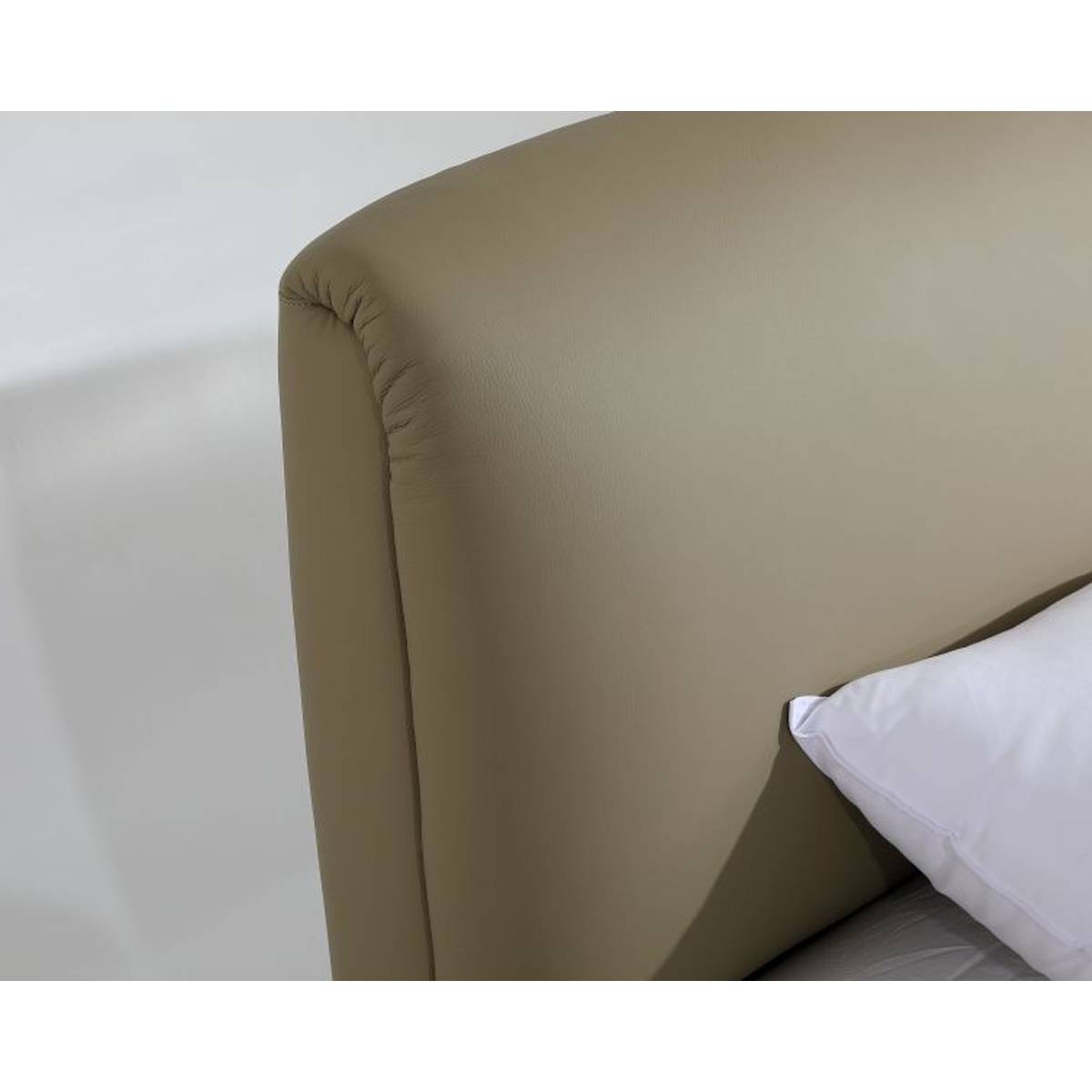 Close-up of the beige leather headboard corner showing texture and stitching