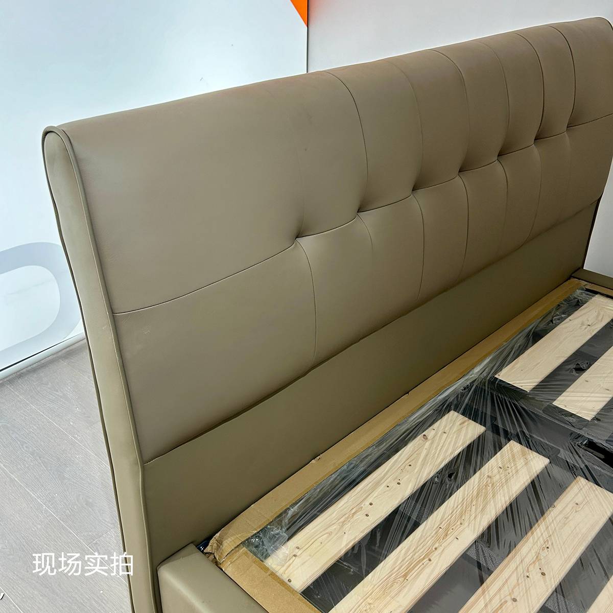 Close-up of the Khaki leather tufted headboard and wooden bed slats