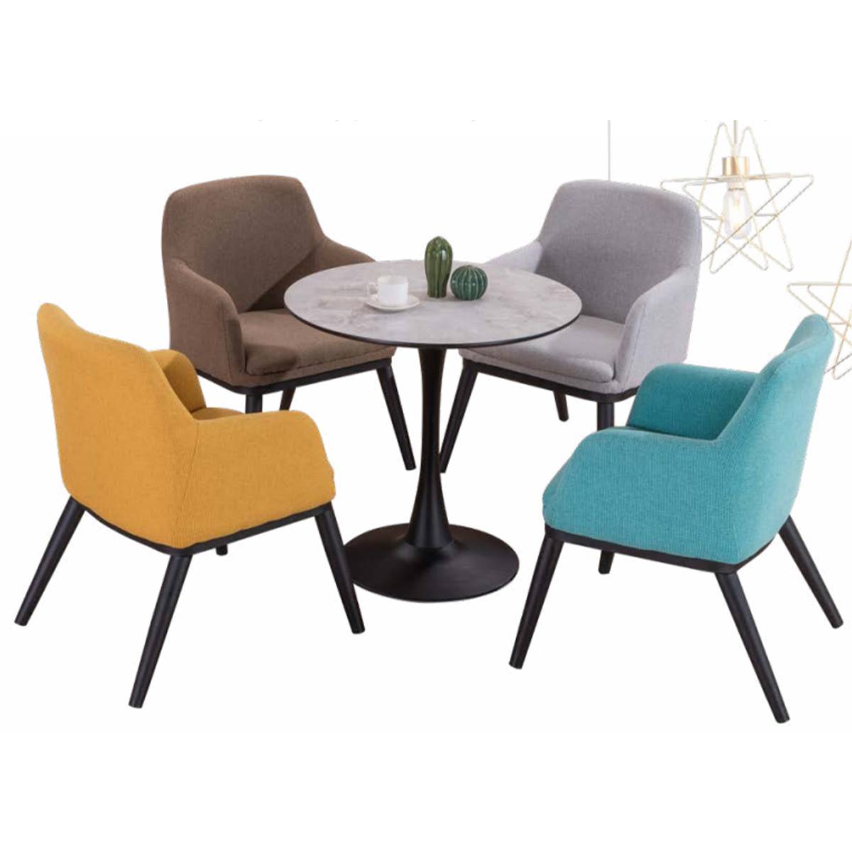 The round table surrounded by four colorful armchairs in a cafe setting, showing the table in use.