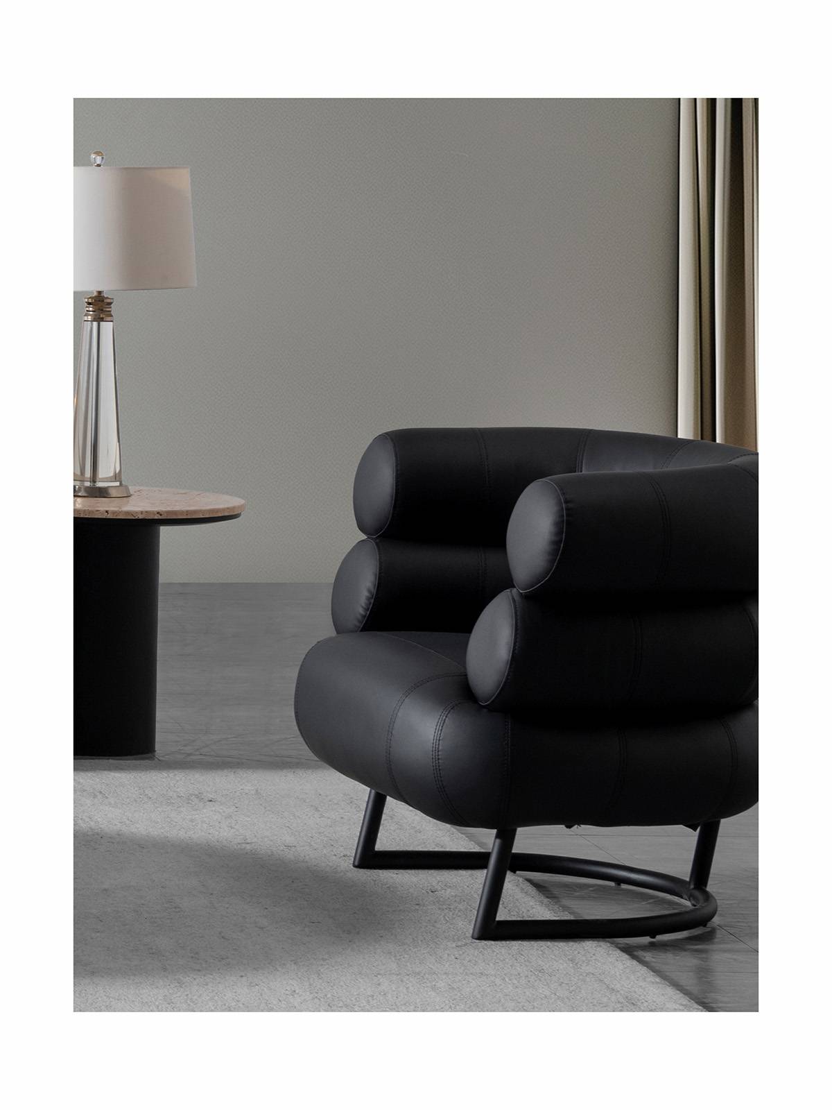 Lifestyle shot of the black leather lounge chair in a modern living room setting
