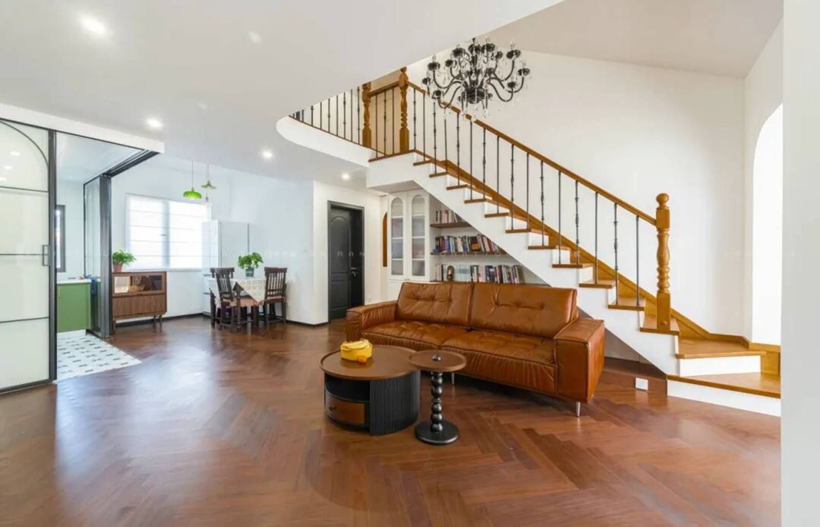 Living room with brown leather sofa and staircase